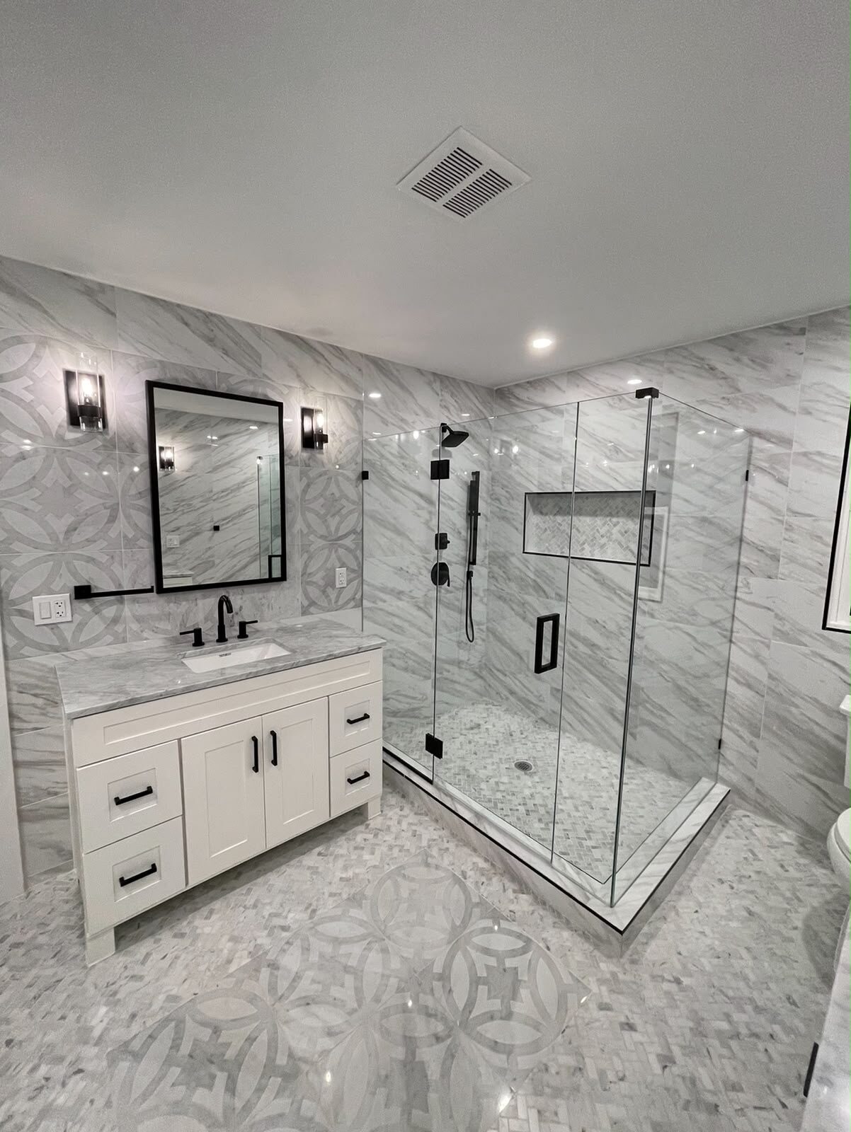 Frameless corner glass shower with marble vanity