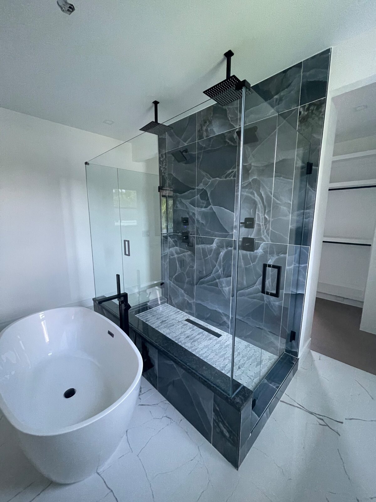 Frameless glass shower next to a freestanding tub