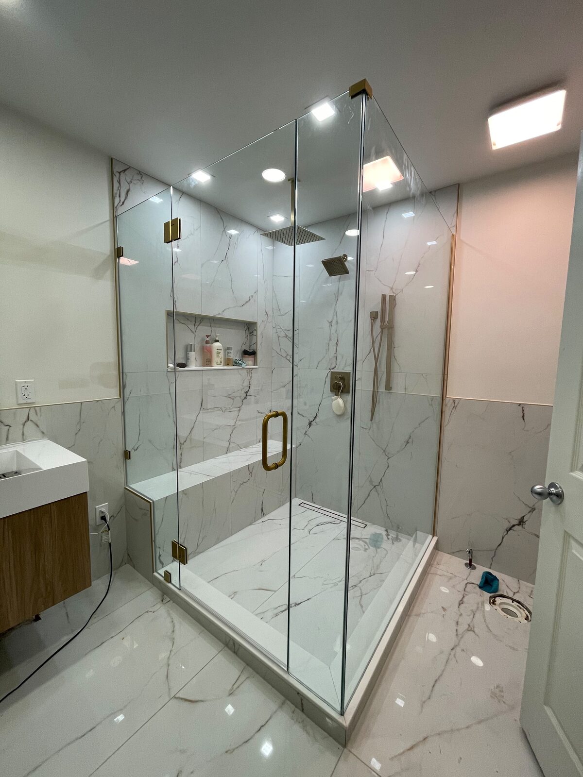 Frameless glass shower with gold hardware