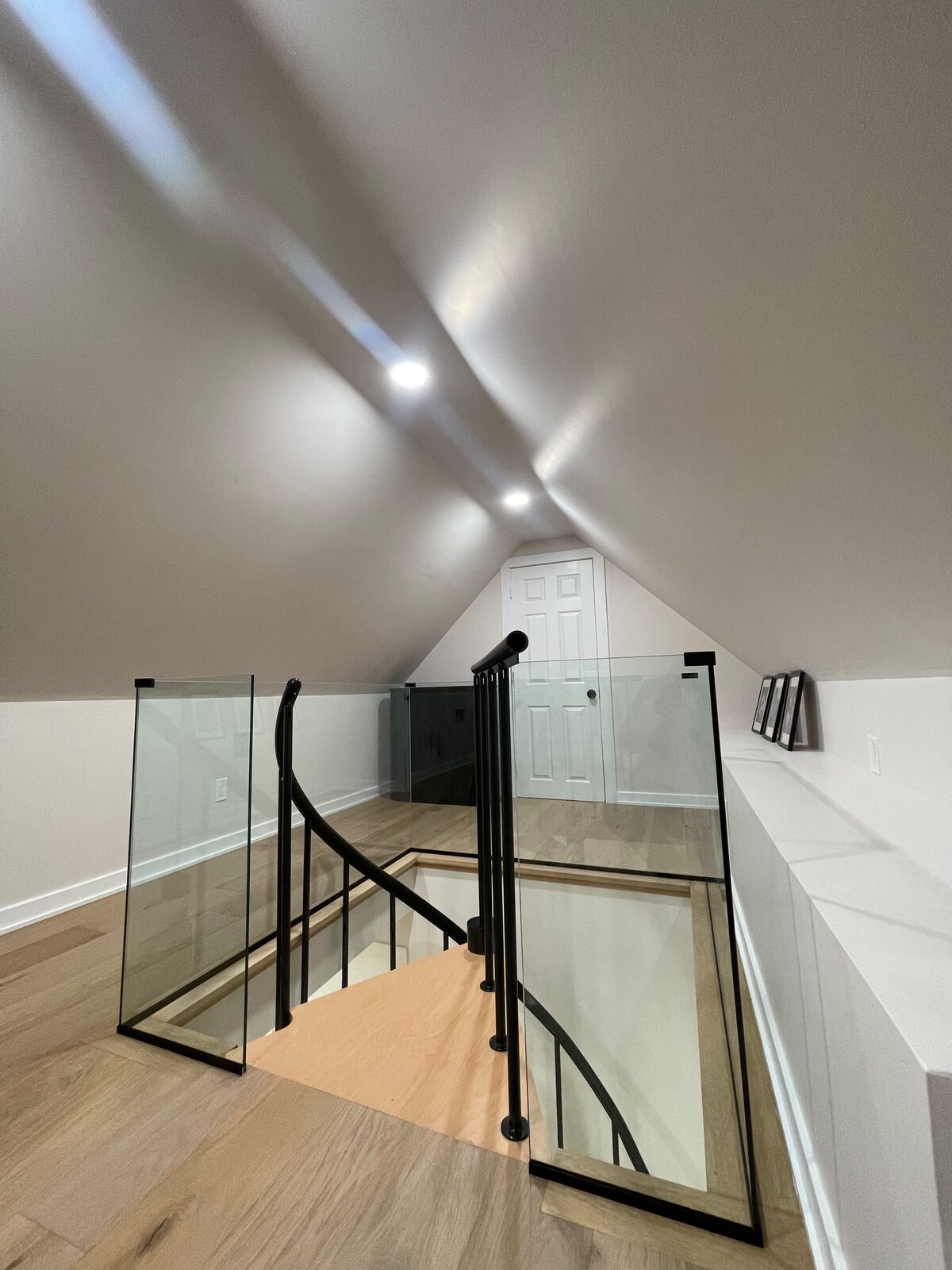 Frameless glass stair railing with black handrail