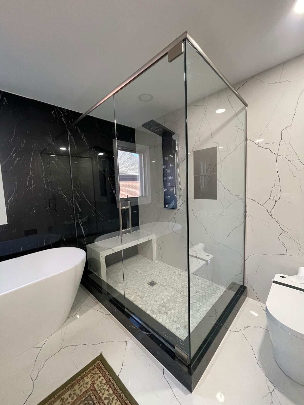Frameless glass shower with black and white marble