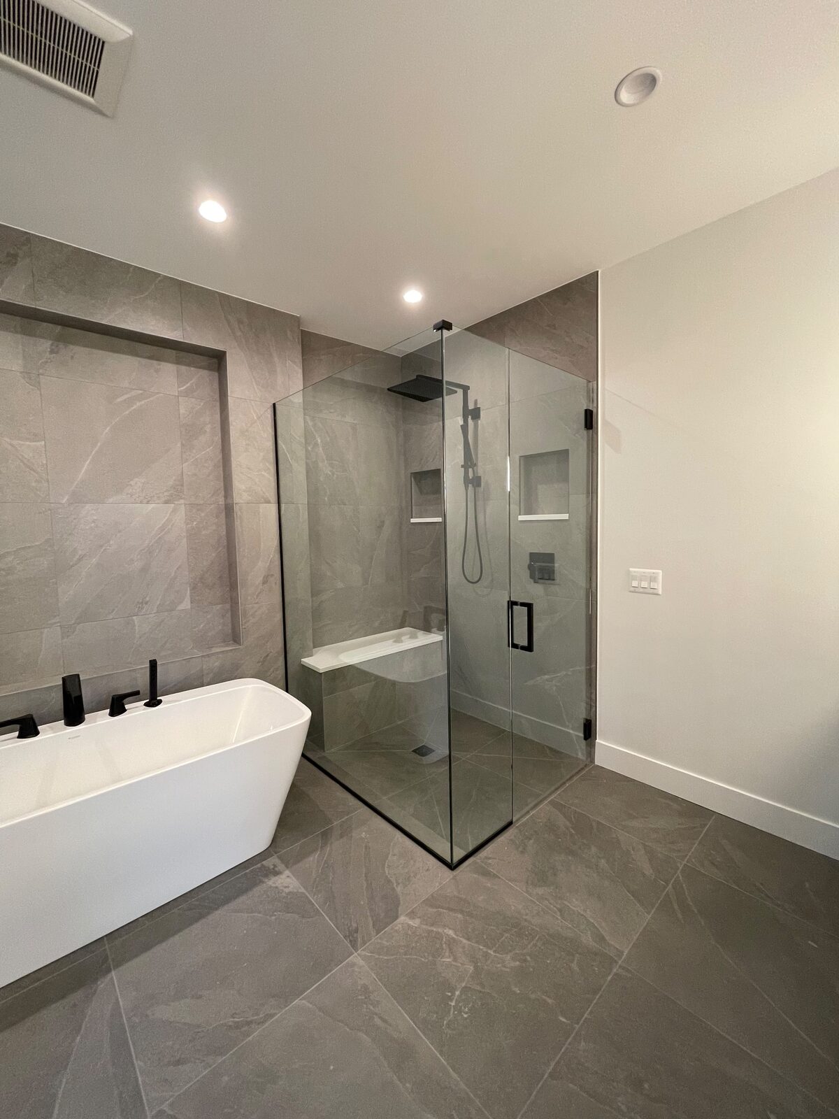 Frameless glass shower with gray marble