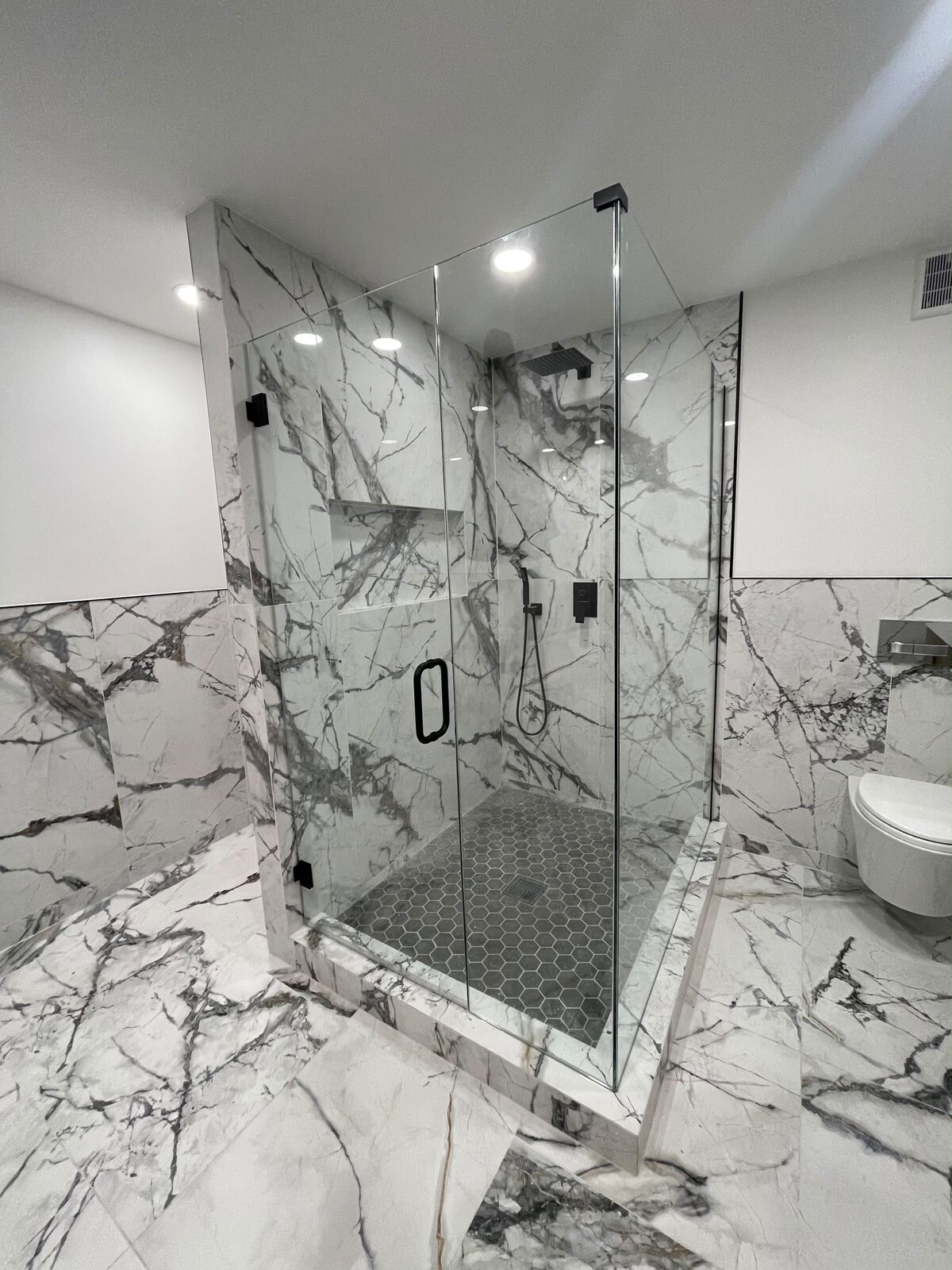 Frameless glass shower with matte black hardware