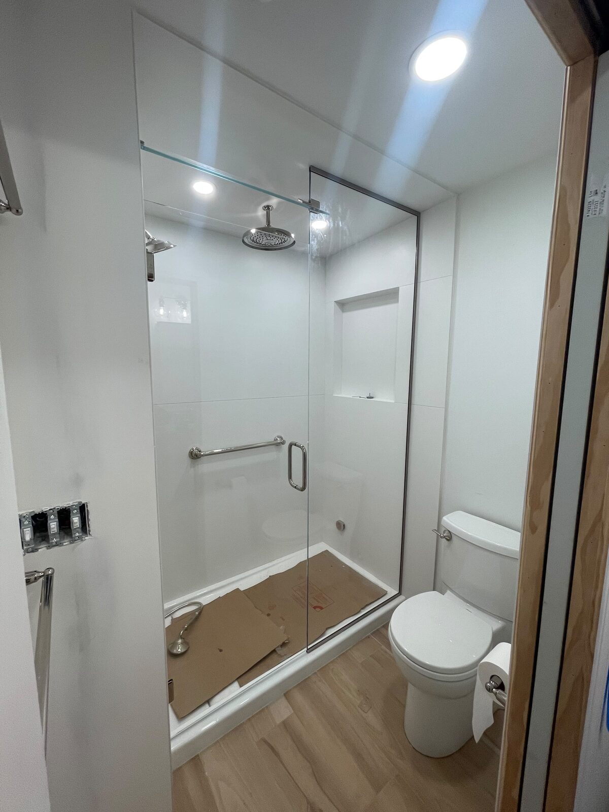 Frameless glass shower door with chrome hardware