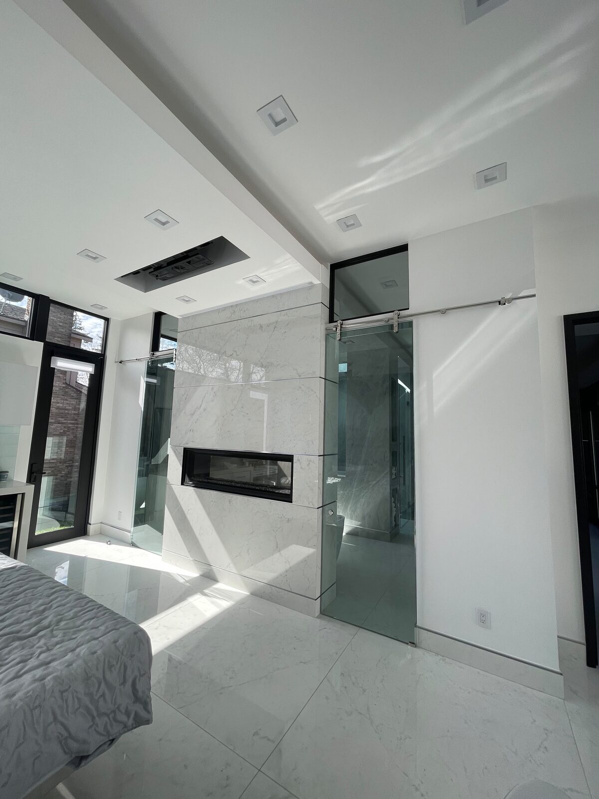 Glass partition in a master bedroom with fireplace