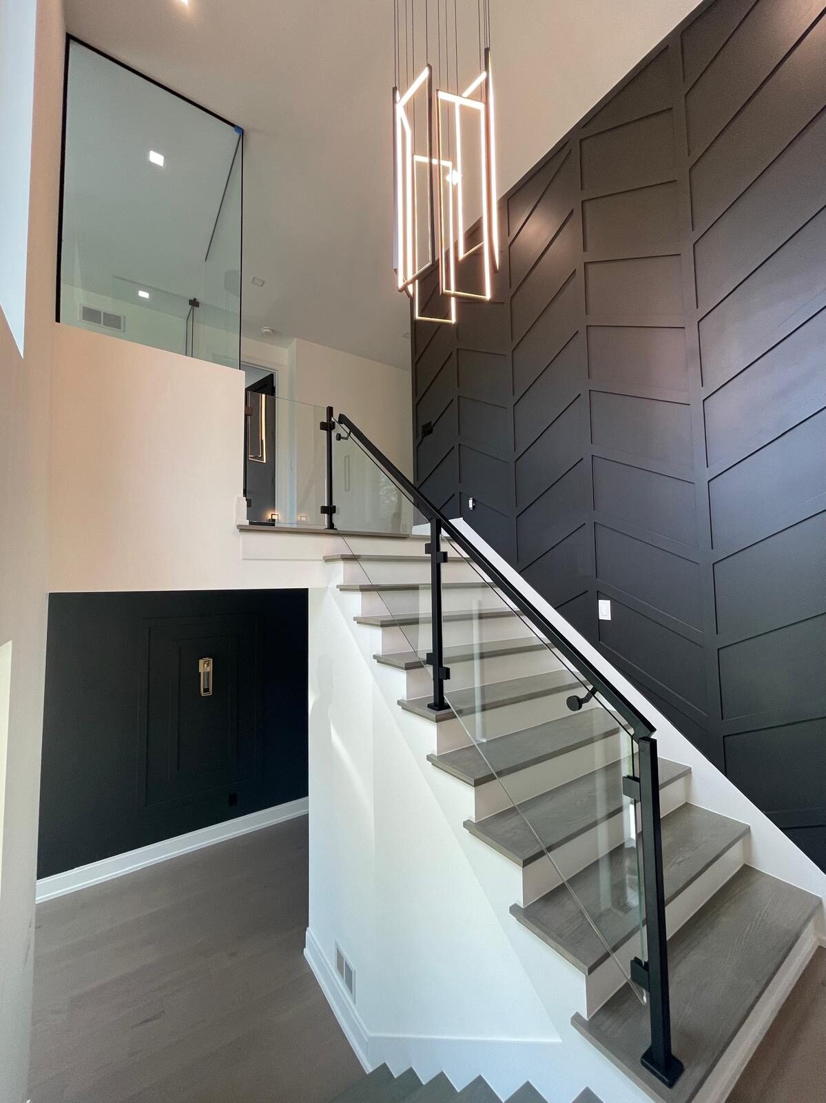 Glass stair railing against a chevron accent wall