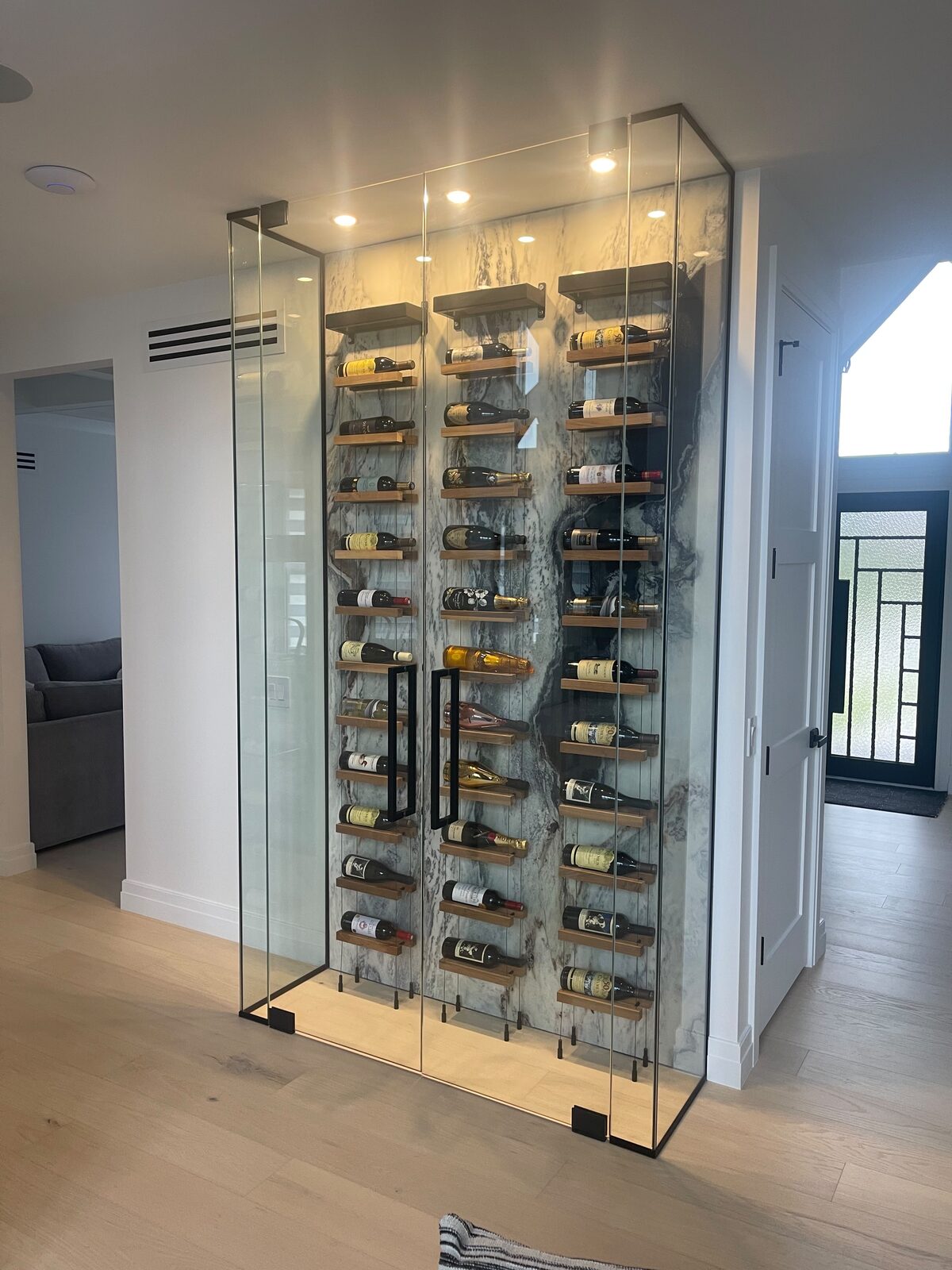 Glass wine cellar with marble backsplash