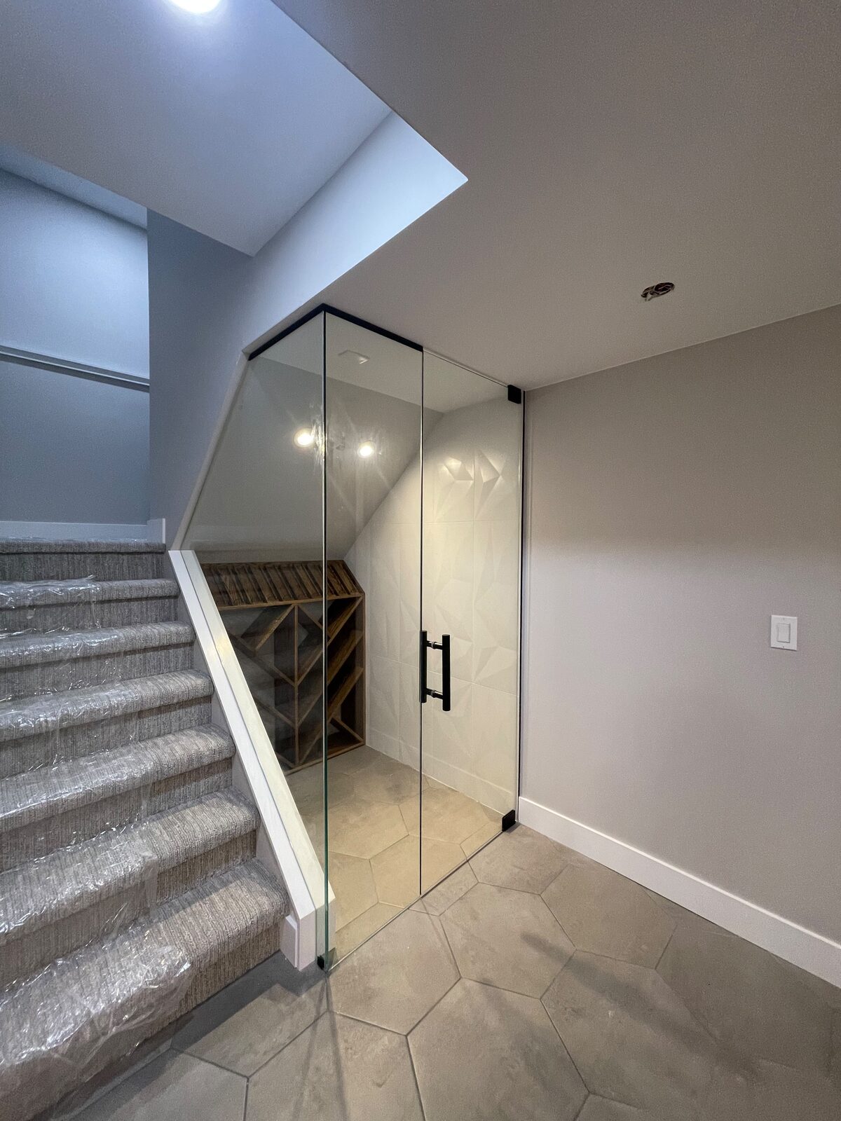 Glass wine cellar built under the stairs